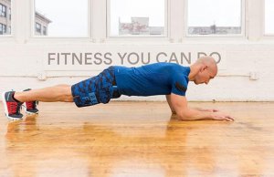 Atletische man doet een planking oefening in de sportschool