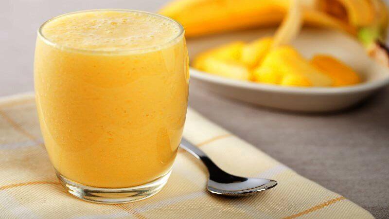 Smoothie met mango limoen en vanille in glas op tafel