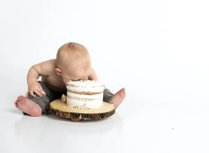 bébé avec la tête dans un gâteau