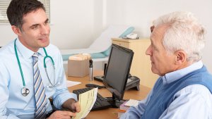 arts praat tegen een oude mannelijke patiënt