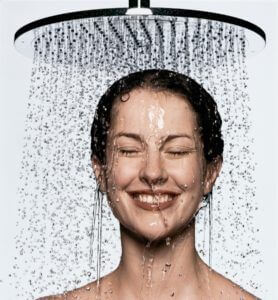 Genietende vrouw staat onder de douche