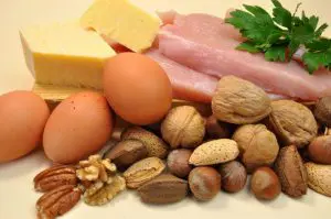 vetrijke voedingsmiddelen op tafel waaronder noten, kaas en eieren