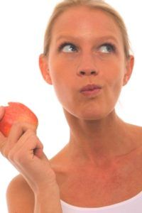 vrouw kauwt op appel en denkt na