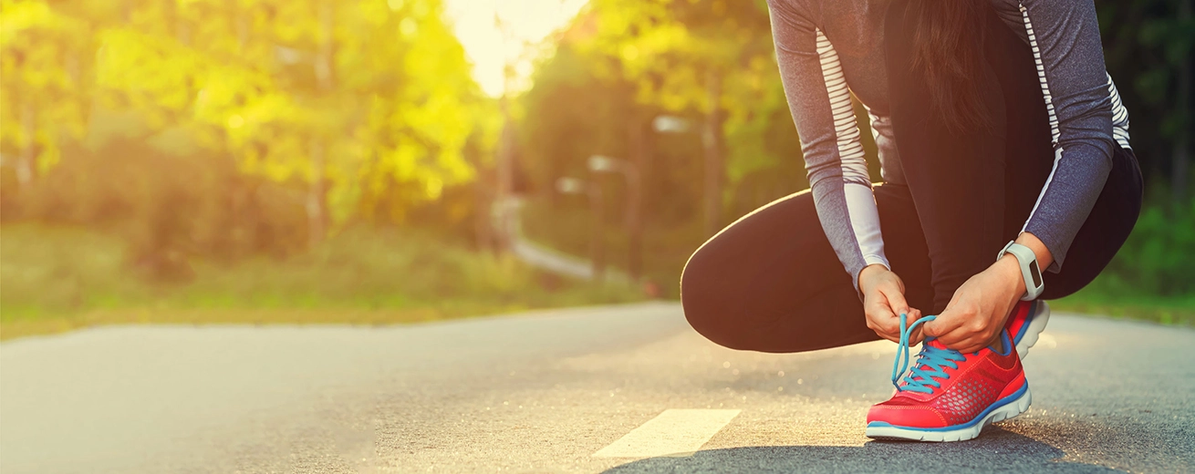 46209273 – female runner tying her shoes preparing for a run a jog outside
