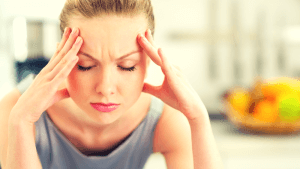 vrouw heeft zichtbaar last van hoofdpijn