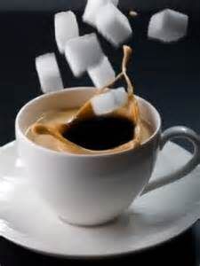 Suikerklontjes vallen in een kopje koffie 