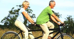 oudere man en vrouw op tandem fiets