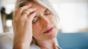Oudere vrouw heeft last van migraineaanval 