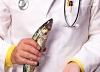 arts in witte doktersjas houdt een vis en visole capsules vast