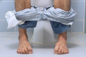 man ervaart buikklachten tijdens toiletbezoek 