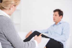vrouwelijke psycholoog luistert naar mannelijke patiënt 
