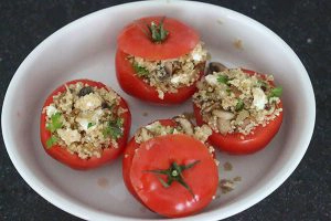 gevulde quinoa tomaatjes in een wit ovenschaaltje