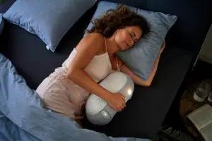 Vrouw ligt met slaaprobot in bed