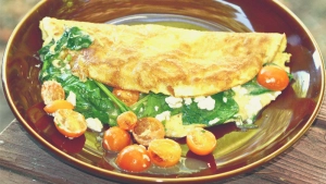 Spinazie omelet met cherry op bord