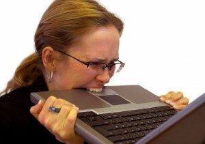 Stressvolle vrouw bijt op laptop
