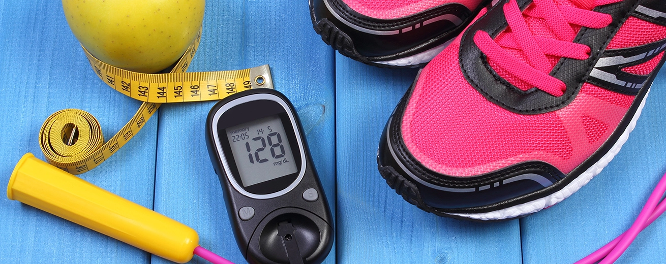 Glucosemeter met sportschoenen, appel en fitness spullen op tafel