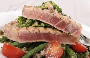 gebakken tonijn met groenten op een bord