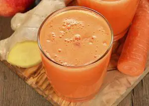 oranje smoothie in glas met wortel en gember