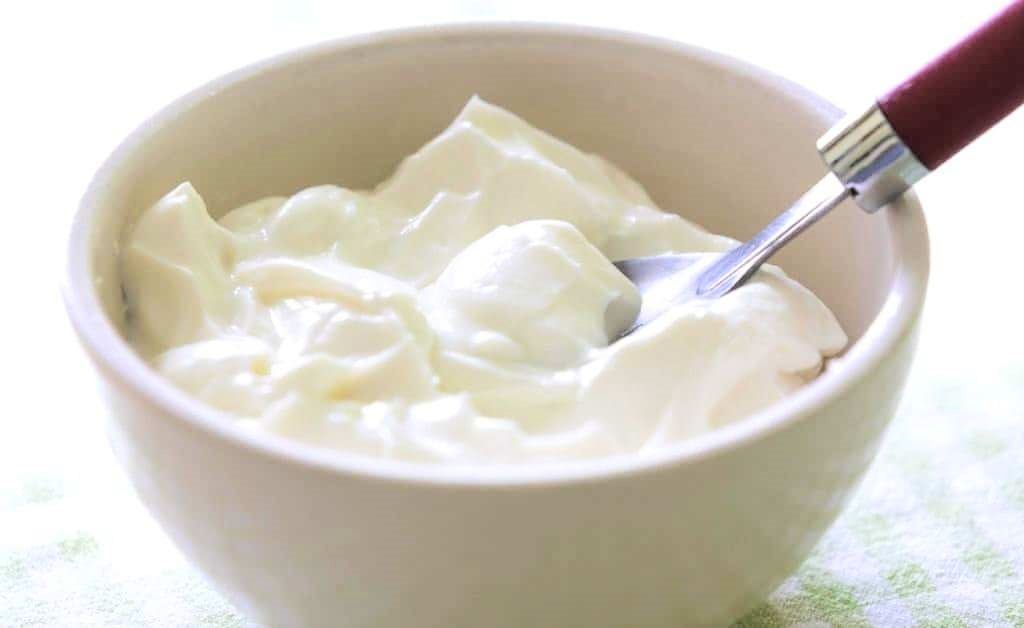bakje yoghurt met zilveren lepel