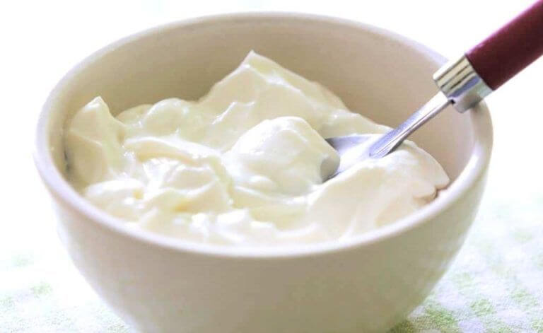 bakje yoghurt met zilveren lepel