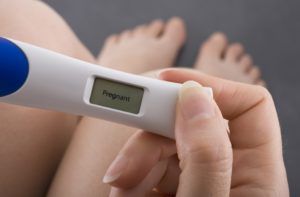 vrouw kijkt naar de uitslag van haar zwangerschapstest 