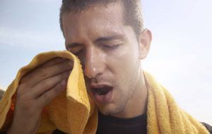 sportende man veegt zweet af met handdoek 